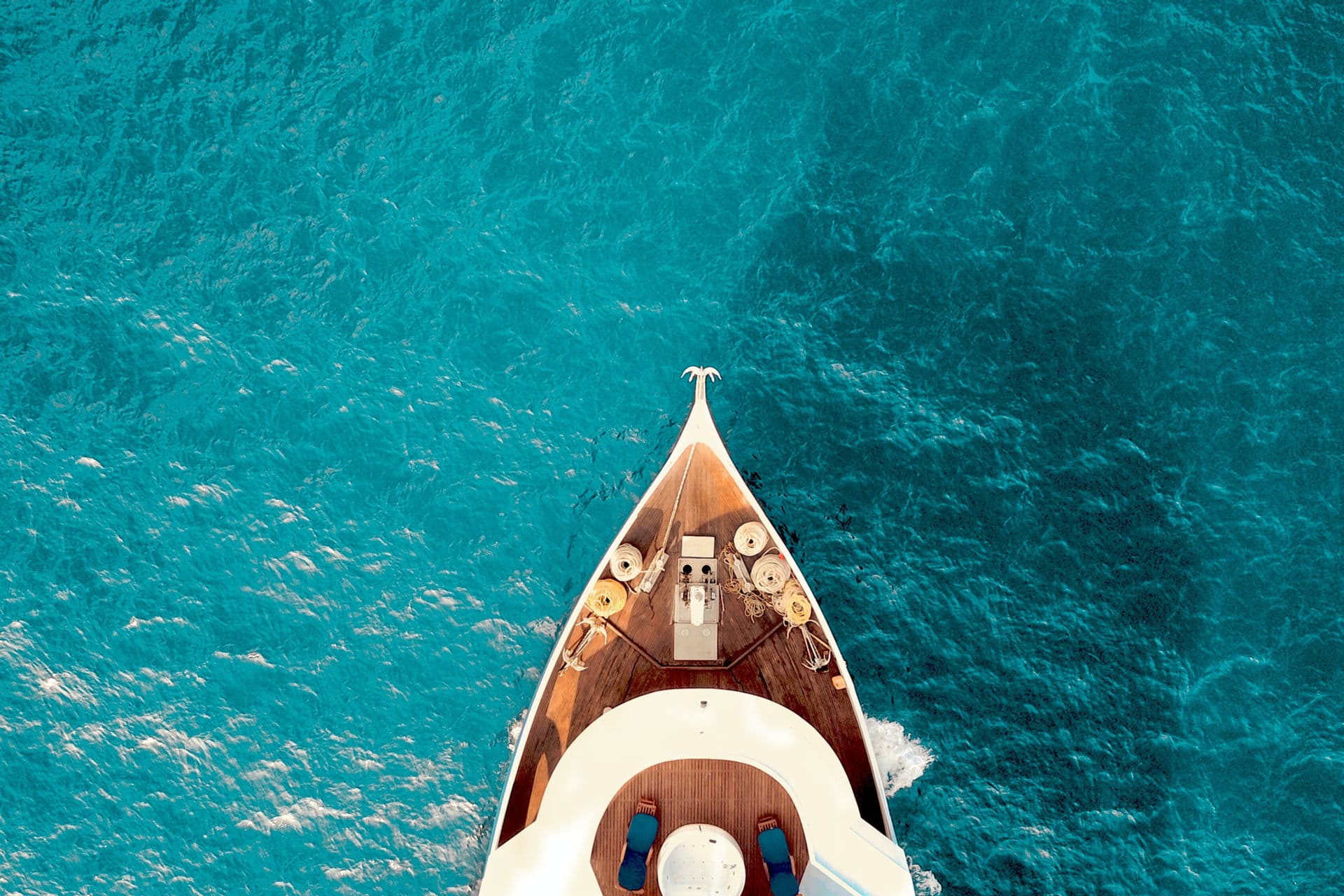 Bow of luxury vessel cutting through turquoise waters
